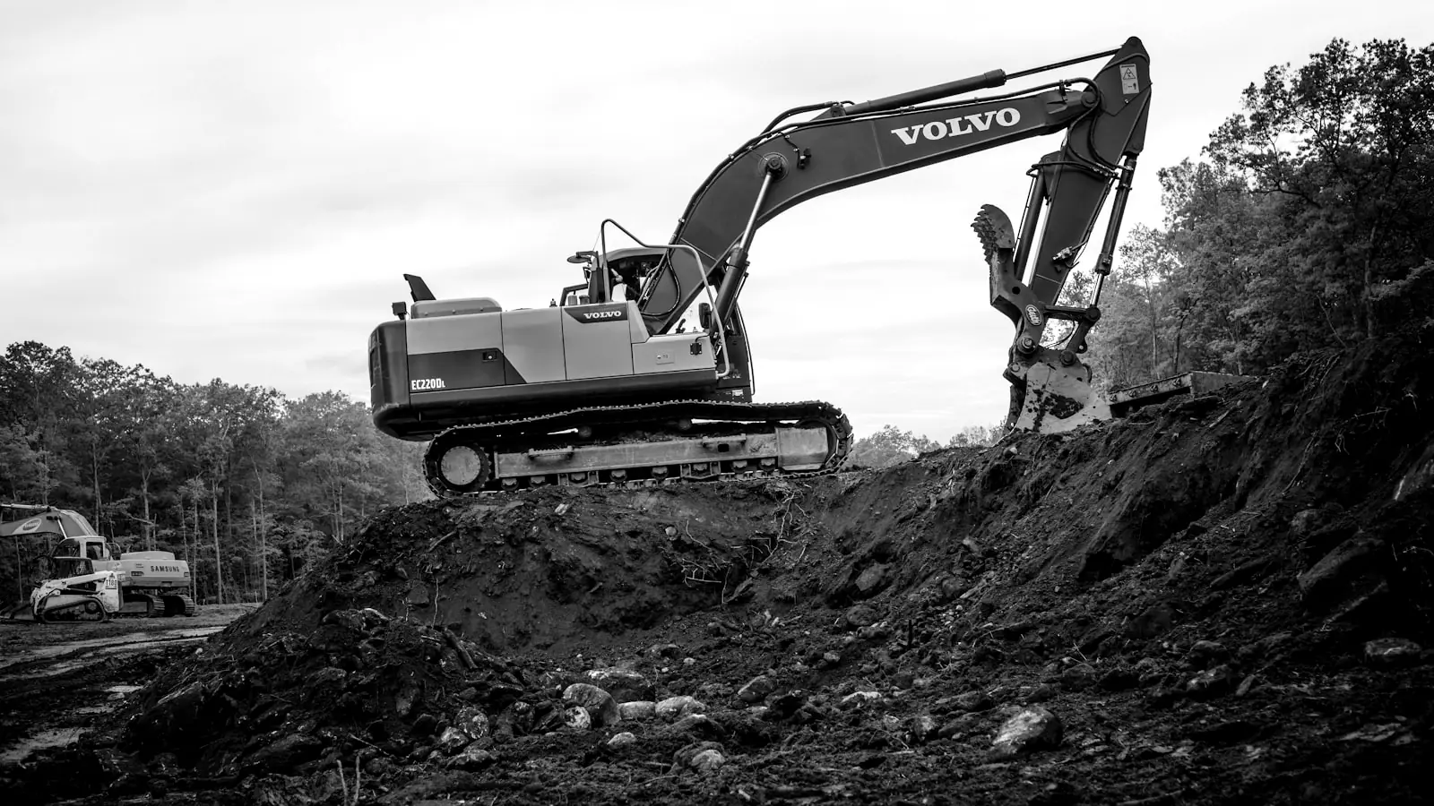 Excavator working a graded slope on an active job site